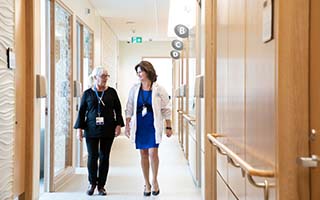 Two staff members walk down a hallway